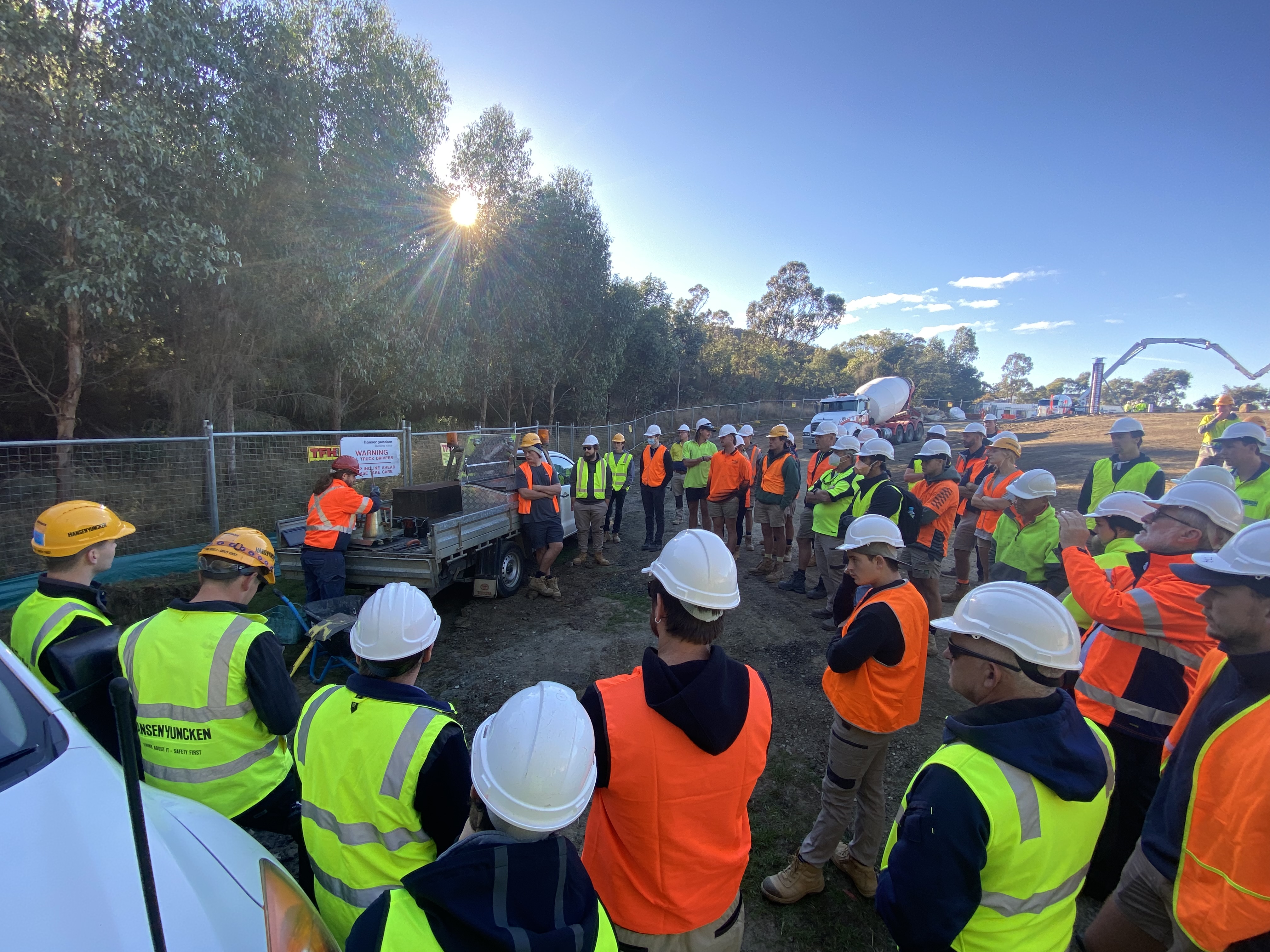 Group of people standing in muddy ground in Hi Vis clothing