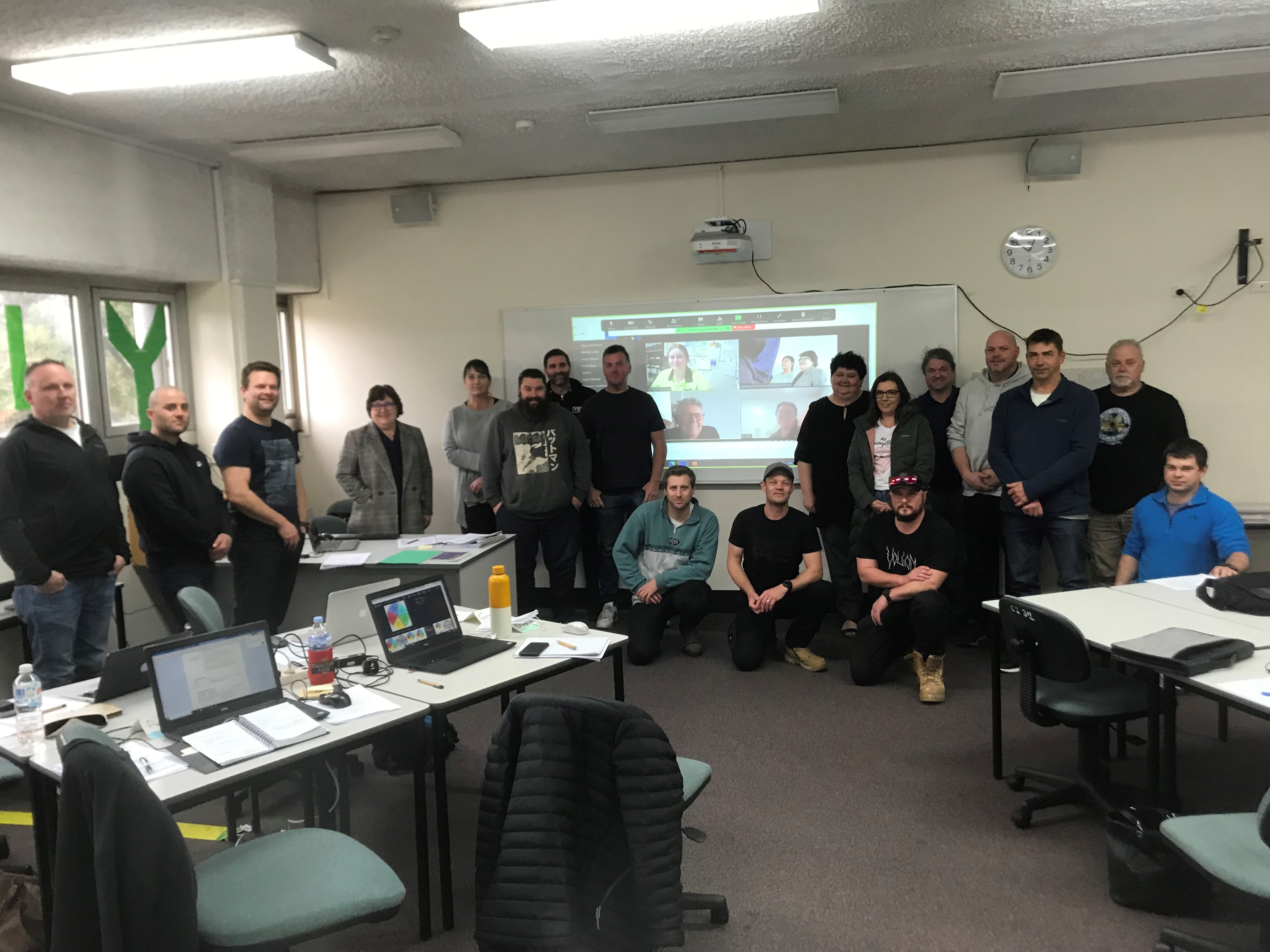 Group of people pose for a photo in the classroom