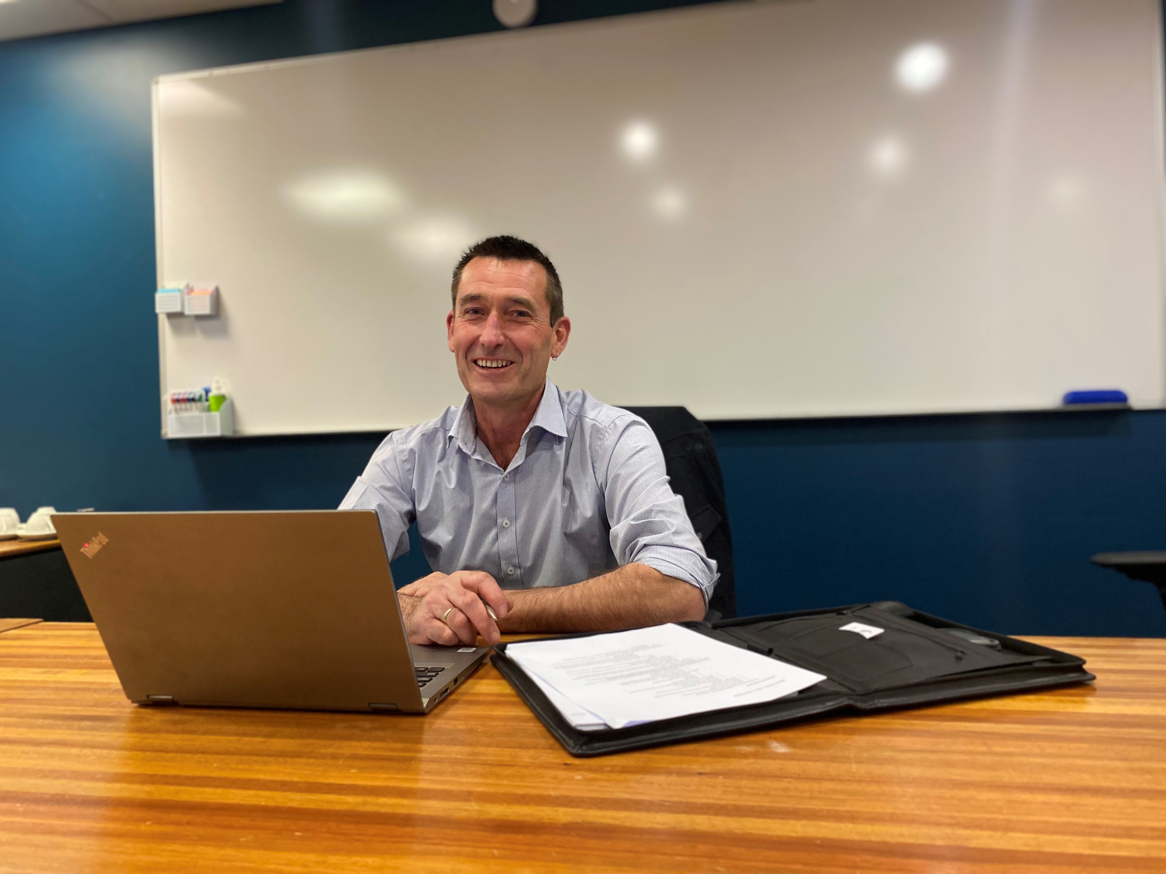 Man sitting at a desk with a laptop.