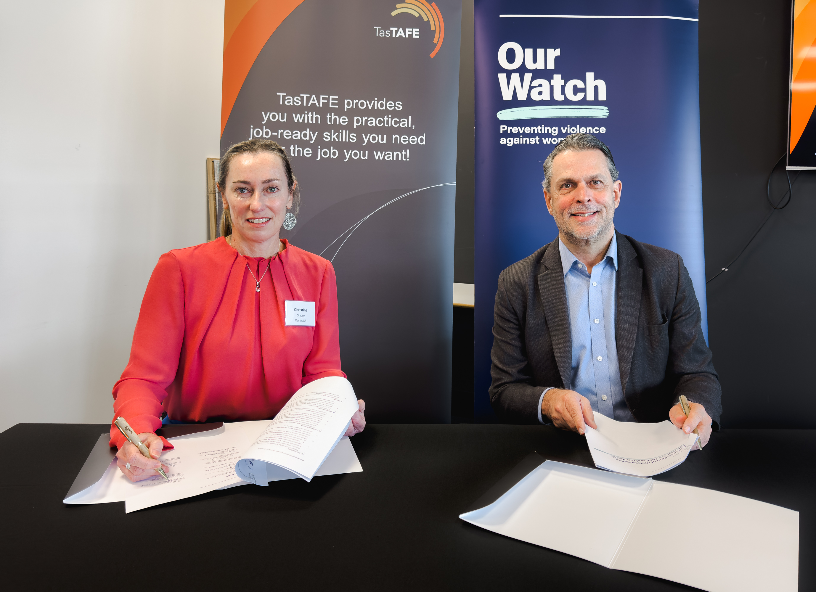 TasTAFE CEO Grant Dreher and MOU representative signing documents at a table