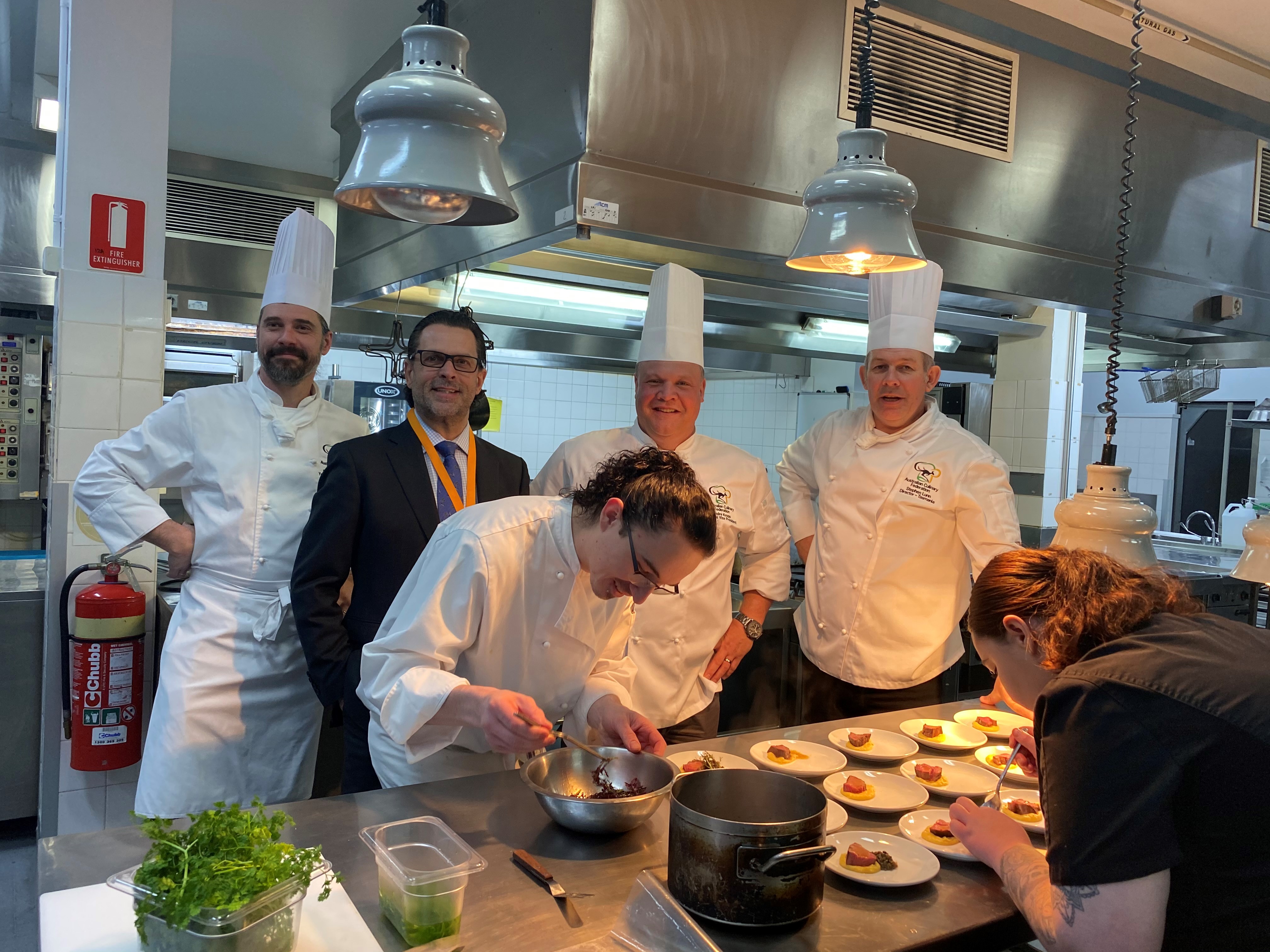 TasTAFE CEO posing with teachers and students for the signing of  a new partnership between the Australian Culinary Federation and TasTAFE Drysdale